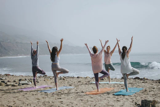 five ladies on the beach doing yoga